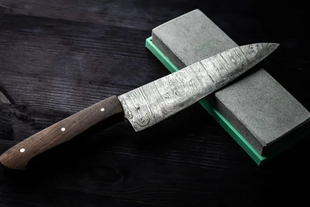 Someone sharpening a knife on a whetstone.